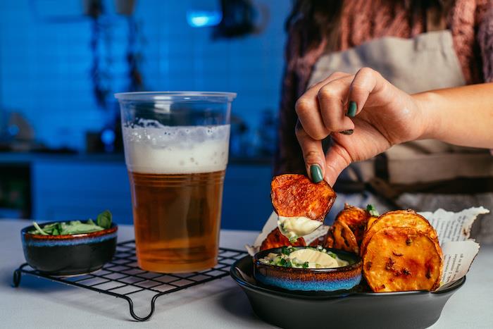 hemlagat potatischipsrecept, chips placerade i svart skål, svart skål med majonnäs och öl bredvid