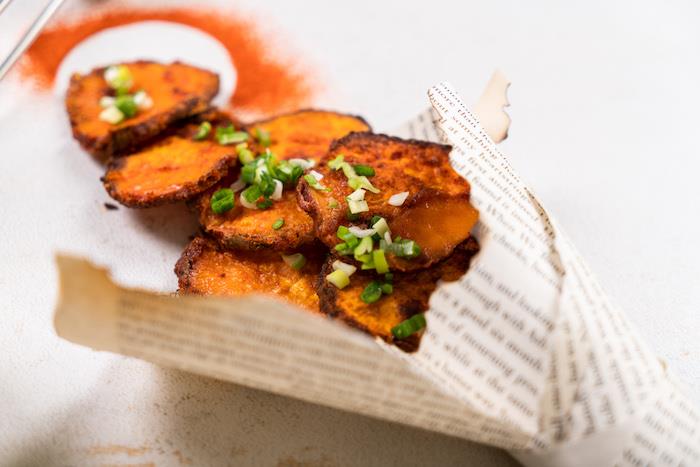 bakad potatis och sötpotatis, placerad på papper, recept på hemlagad potatischips, gräslök ovanpå