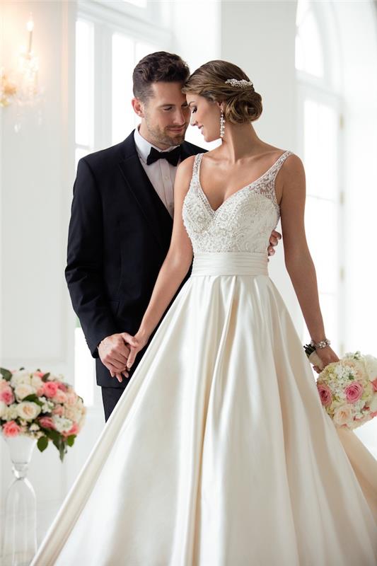 Uomo e donna che si tengono per mano، sposa da Principessa. abito bianco con ornamenti