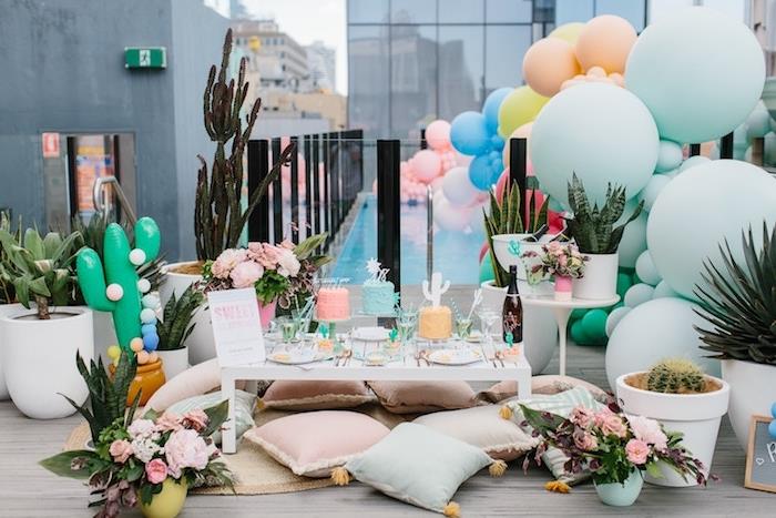 bohemiskt chic kvällstema på terrassen, ballonger i pastellfärger och olika storlekar., vitt soffbord och bohemiska chica kuddar vid golvet