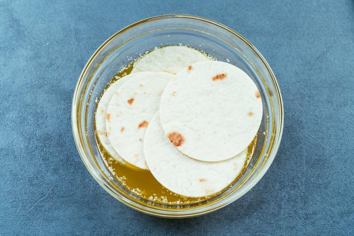 tortillainpackningar, blötlagda i smör, hur man gör tacos, glasskål, blått bord