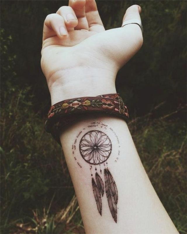 Dreamcatcher -tatuering på armen, rosfönster och svarta fjädrar, rundformat citat, indianarmband med blommotiv