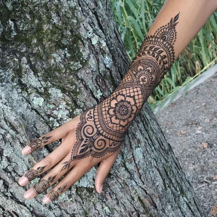 henna model ruky, dočasné čipkované tetovanie s dizajnom mandaly na rukách a prstoch