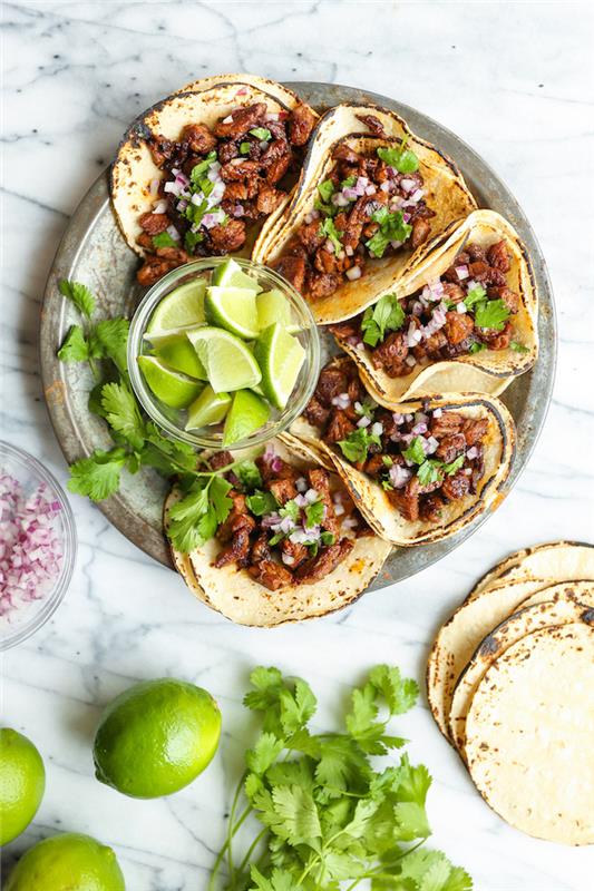 fem tacos, tortillainpackningar, fyllda med nötkött, hur man gör tacokött, arrangerat på en silverfat, limeskivor, i en glasskål